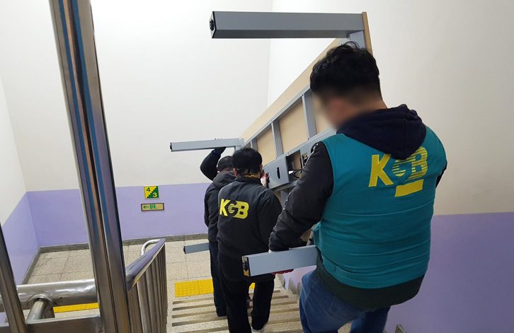 계단으로 사무실 집기를 옮기는 KGB 넘버원 기업이사 작업자